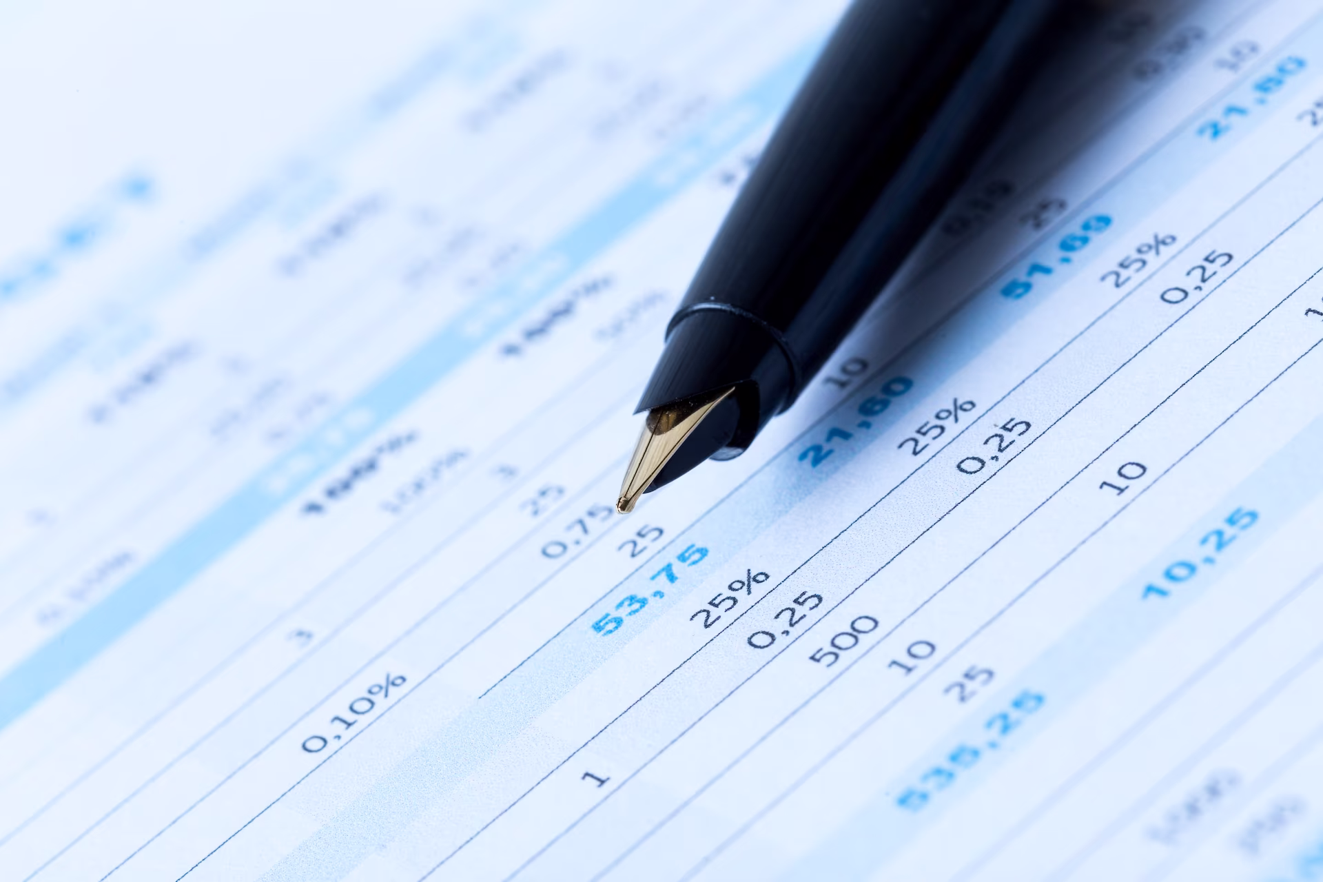 Pen on top of paper displaying data tables