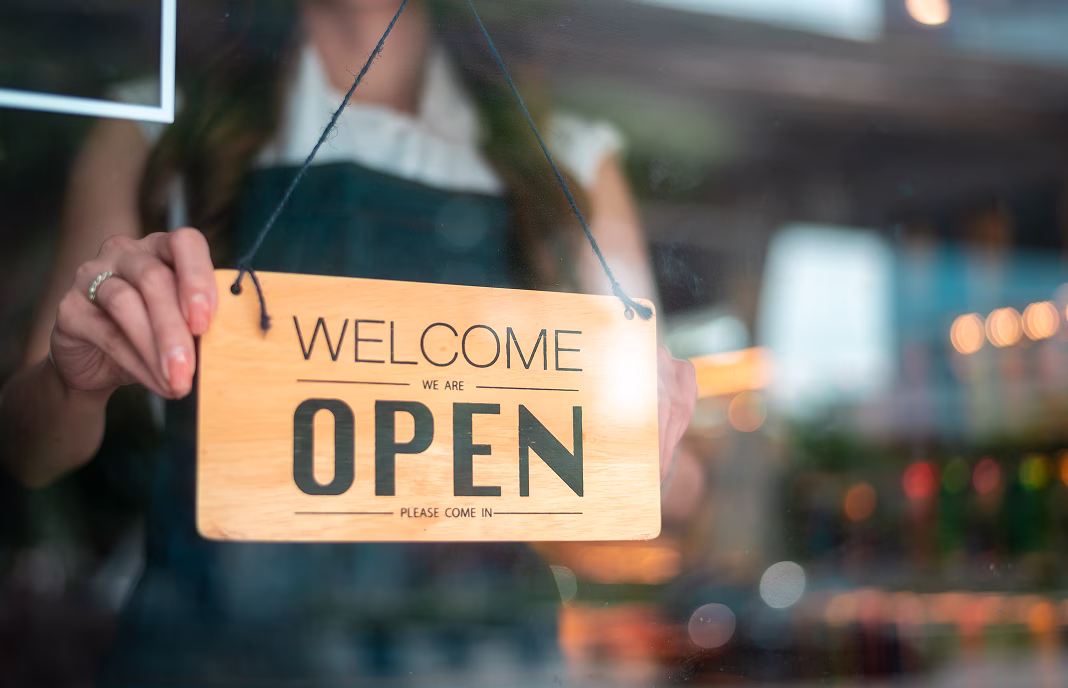 A business owner putting out an open for business sign
